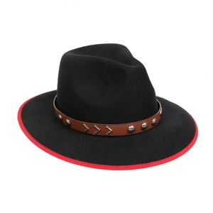 Detail of black wool fedora featuring red trim and brown leather band with metal studs