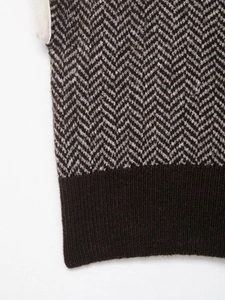 Macro shot of brown herringbone knit texture with dark ribbed hem finish details
