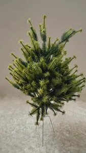 Detailed close-up of a green flocked mini Christmas tree with a snowy texture finish