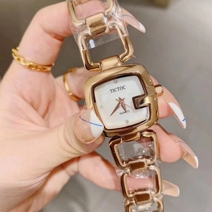Detail of elegant gold square watch with quartz movement and crystal hour markers