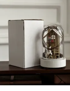 Detailed Christmas glass dome with wooden miniature cabin and gift packaging box