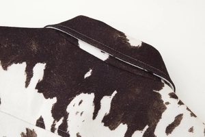 Detail of cow print cropped jacket showing collar stitching and soft suede texture