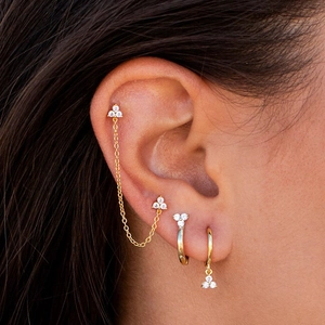 Close-up of gold plated ear set with zircon chains and hoops on model ear