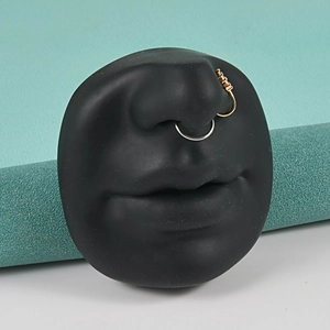 Detailed view of gold crystal nose stud and silver hoop on realistic silicone nose model