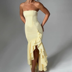 Detail of light yellow tube top mermaid dress with ruffled asymmetrical hem and satin finish