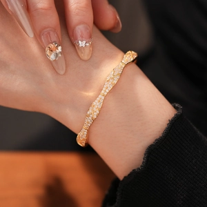 Close-up of gold-plated bangle with pave-set cubic zirconia on a female wrist