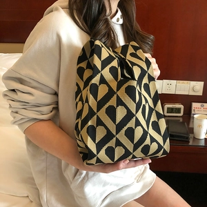 Close-up of heart pattern knitted tote bag in black and khaki colors with soft texture