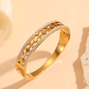 Détails du bracelet doré ajouré avec motif floral et incrustations de cristaux brillants