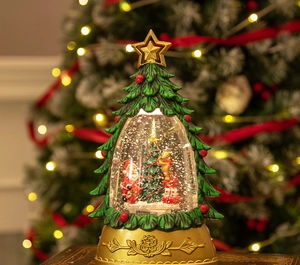 Close-up of a lit Christmas tree snow globe with a Santa figure and golden base