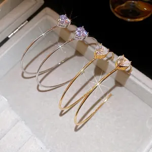 Boucles d'oreilles cœur en zircone plaqué or et argent dans un écrin de bijoux gris