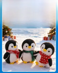 Detailed view of plush Christmas penguins wearing festive scarves in a snowy outdoor scene