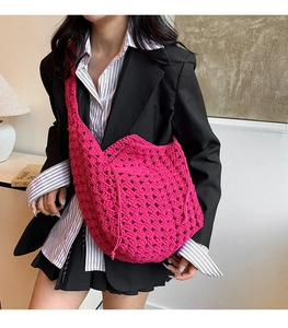 Dettaglio della borsa hobo fucsia all'uncinetto con motivi geometrici e tracolla
