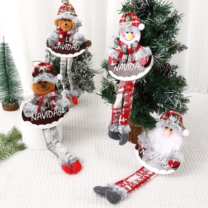 Festive Christmas plush ornaments with long legs and Feliz Navidad signs on a holiday table