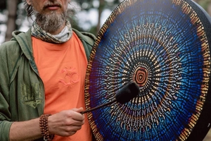 Detailed close-up of a handmade mosaic frame drum with colorful mandala patterns in nature