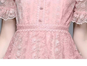 Close-up of pink lace dress featuring intricate floral embroidery and waist lace details