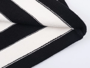 Close-up of black and white striped knitwear showing ribbed edges and fine texture
