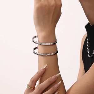 Silver geometric segmented bangle in stainless steel with a high-polished mirror finish