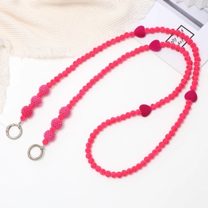 Detail of fuchsia beaded crossbody chain with heart charms and metal spring hooks