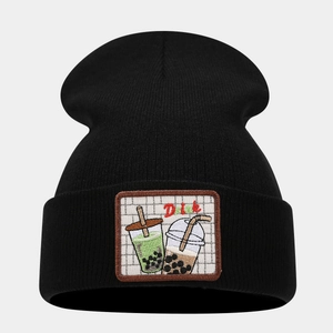 Detail of black knit beanie featuring a pearl milk tea embroidery and Drink label