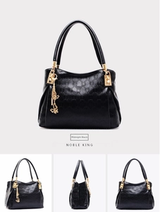 Detail view of Midnight Black embossed leather bag with golden butterfly charm