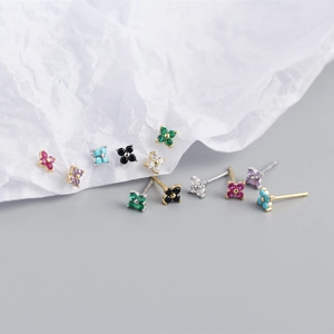 Detailed macro view of small S925 silver four-leaf flower earrings with colorful zircon