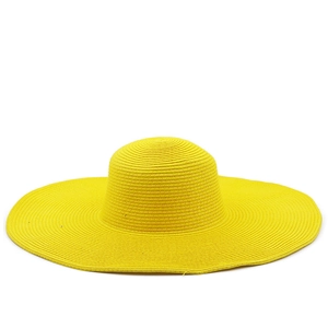 Close-up of bright yellow straw sun hat showing fine spiral woven texture and wide brim