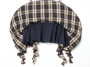Detail of brown plaid fabric featuring a navy blue layered ruffle hem and precise stitching