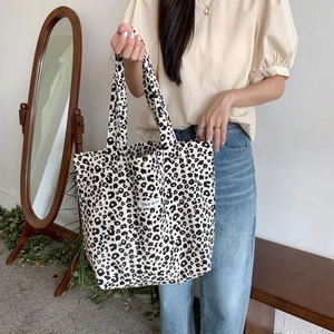 Detailed view of leopard print canvas tote bag with woven label in a vintage home setting