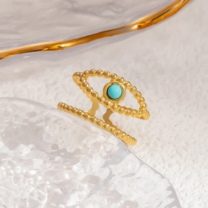 Detailed macro of gold beaded double-layer ring featuring a central turquoise stone