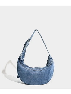 Detail of blue denim hobo bag showing adjustable strap with silver buckle and fabric texture