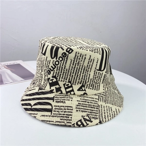 Détail du chapeau bob beige avec imprimé journal vintage noir sur toile de coton