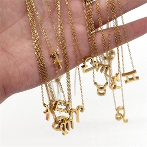 Vue détaillée de divers pendentifs et chaînes du zodiaque en or 18k tenus à la main