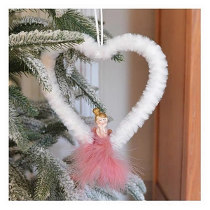 Detail of pink feather dress ballerina angel ornament on snowy Christmas tree