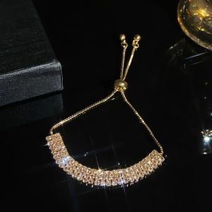 Detail of adjustable gold-tone tennis bracelet with triple rows of sparkling crystals
