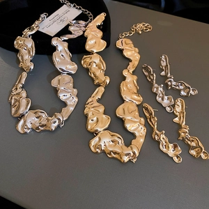 Detailed close-up of gold and silver irregular lava style liquid metal jewelry set