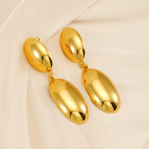 Vue détaillée de boucles d'oreilles ovales doubles dorées sur un tissu en soie beige