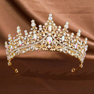 Luxurious gold bridal crown with sparkling crystals on brown silk background