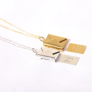 Detailed shot of gold and silver envelope necklaces with hidden Love You engraved insert