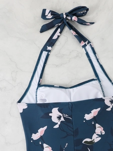 Detail of floral halter swimsuit with deep blue print and tie back neck closure