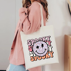 White Halloween canvas tote bag with spooky leopard smiley print and pink accents