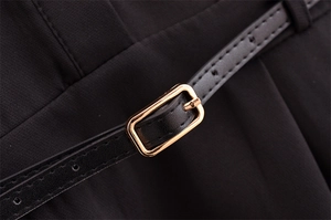 Detail of black dress fabric with matching slim belt and golden square buckle