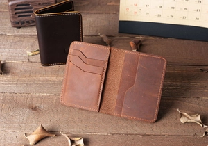 Macro shot of crazy horse leather wallet with card slots on a rustic wooden desk