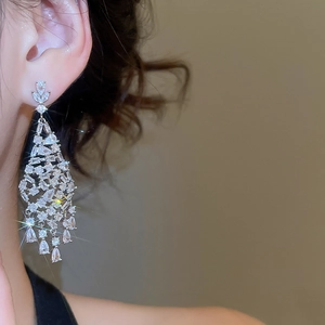 Gros plan sur des boucles d'oreilles chandelier en argent serties de zircons brillants