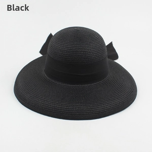 Close-up of the woven texture and black ribbon bow detail on the summer straw sun hat
