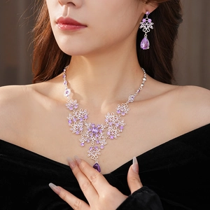 Detail of vintage flower necklace and teardrop earrings set with purple crystals