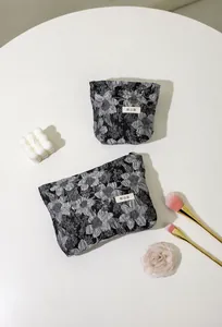Vue détaillée de dessus des trousses à maquillage en jacquard floral avec accessoires beauté