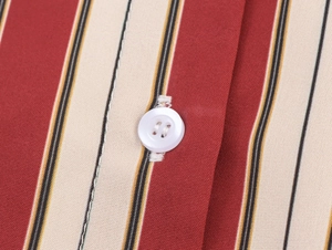 Gros plan du tissu de chemise à rayures avec bouton blanc et texture tissée précise