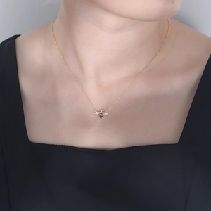Elegant s925 sterling silver golden bee necklace with sparkling crystals worn by a model
