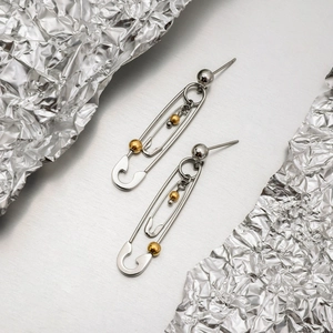 Detail of titanium steel paperclip earrings in two-tone 18K gold and silver finish