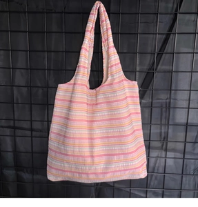 Gros plan détaillé sur le tissu gaufré à rayures colorées et la texture du sac cabas